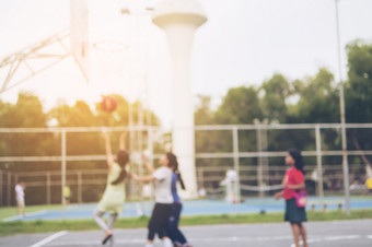 模糊照片亚洲孩子们是玩篮球与温暖的太阳光从前正确的角落里