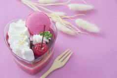 色彩斑斓的草莓蛋糕和macaron粉红色的背景