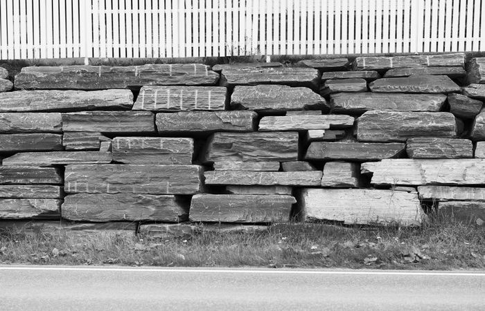 黑色的和白色多石的城市墙与栅栏背景黑色的和白色多石的城市墙与栅栏背景