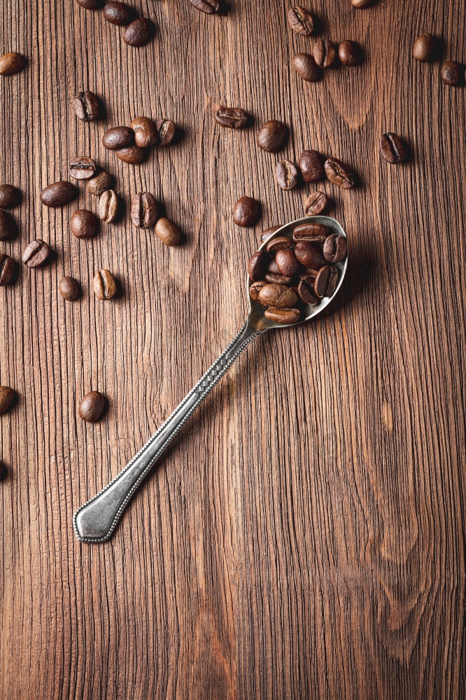 咖啡豆子与金属勺子木背景咖啡豆子与金属勺子