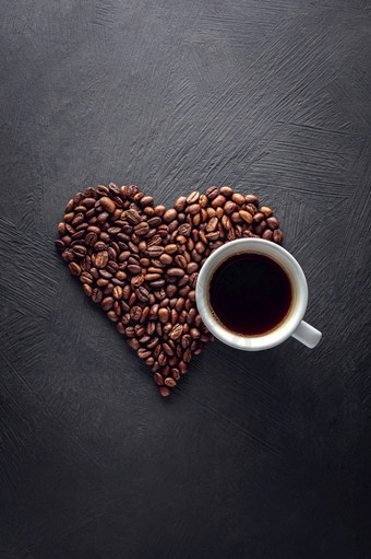 咖啡杯与心形状豆子黑色的变形背景咖啡杯与心形状豆子