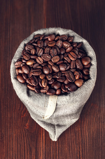粗麻布袋与咖啡豆子粗麻布袋与咖啡豆子木背景