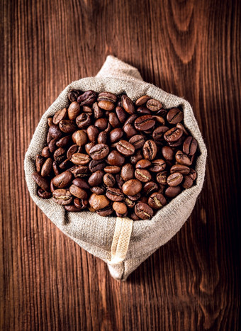 粗麻布袋与咖啡豆子粗麻布袋与咖啡豆子木背景