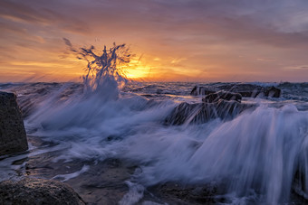 令人惊异的飞溅海<strong>水日</strong>出的海岸的黑色的海美丽的运动模糊海波在的岩石低角视图