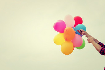 手十几岁的女孩持有色彩斑斓的气球的阳光手十几岁的女孩持有色彩斑斓的气球的阳光夏天