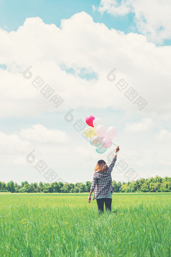 回来年轻的赶时髦的人亚洲女人与彩色的气球草场回来年轻的赶时髦的人亚洲女人与彩色的气球草