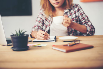 业务女人持有杯咖啡和写作业务计划业务女人持有杯咖啡和写作业务计划准备好了为工作的早....