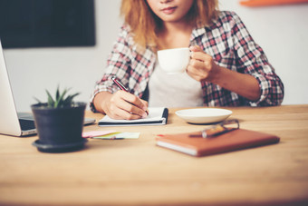 业务女人持有杯咖啡和写<strong>作业</strong>务计划业务女人持有杯咖啡和写<strong>作业</strong>务计划准备好了为工作的早....