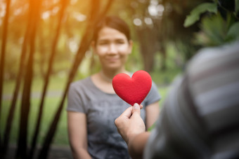 年轻的<strong>男</strong>人</strong>。持有心形状的情人<strong>节</strong>卡和看而站与的女朋友年轻的<strong>男</strong>人</strong>。持有心形状的情人<strong>节</strong>卡和看而