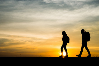 轮廓两个徒步旅行者与背包享受日落旅行轮廓两个徒步旅行者与背包享受日落旅行概念
