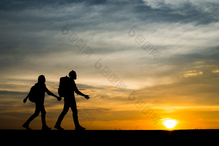 轮廓两个徒步旅行者与背包享受日落旅行轮廓两个徒步旅行者与背包享受日落旅行概念