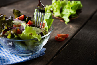 关闭新鲜的蔬菜沙拉与叉的碗准备好了吃健康的食物概念关闭新鲜的蔬菜沙拉与叉的碗准备好了