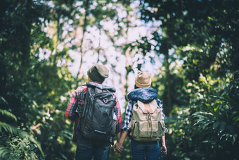 年轻的夫妇走与背包森林冒险上涨享受假期在一起