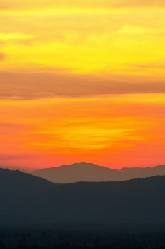 美丽的橙色和红色的天空在山范围后日落