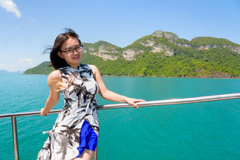 亚洲女人的船亚洲年轻的女人与眼镜微笑幸福的的船而巡航的美丽的自然的蓝色的海和天空夏天这丁字裤国家公园这封信他尼府泰国