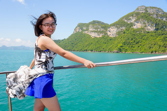 亚洲女人的船亚洲年轻的女人与眼镜微笑幸福的的船而巡航的美丽的自然的蓝色的海和天空夏天这丁字裤国家公园这封信他尼府泰国