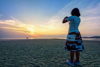 亚洲女人旅游采取照片的海滩和美丽的自然景观色彩斑斓的天空和海在日落纳通日落的观点寒岛这封信他尼府泰国女人旅游采取照片的海滩