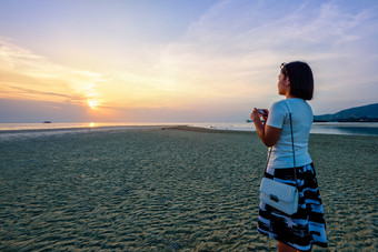 亚洲女人旅游采取照片的海滩和美丽的自然景观色彩斑斓的天空和海在日落纳通日落的观点寒岛这封信他尼府泰国女人旅游采取照片的海滩