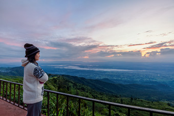 女人旅游毛衣衣服站看的美丽的自然景观的森林和山在的日出的高峰的早....府塔普书的观点碧差汶泰国女人旅游看的日出
