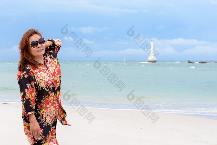 中年女人旅游穿sunglasse看的相机和微笑的海滩和海夏天天空背景KOH塔鲁陶岛satun泰国中年女人的海滩泰国