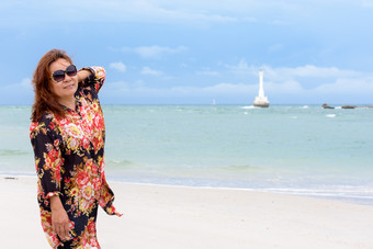 中年女人旅游穿sunglasse看的相机和微笑的海滩和海夏天天空背景KOH塔鲁陶岛satun泰国中年女人的海滩泰国