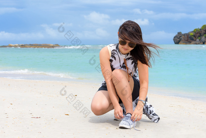 美丽的女人旅游穿sunglasse蹲绑定绳子运动鞋的海滩附近的海在的漫步塔鲁陶岛的夏天假期satun泰国女人绑定绳子运动鞋的海滩泰国