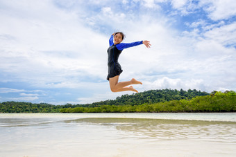 快乐亚洲青少年女孩穿泳衣跳有趣的的海滩下的蓝色的天空在的海之旅假期夏天假期利普岛塔鲁陶国家公园satun泰国快乐亚洲青少年女孩跳有趣的的海滩