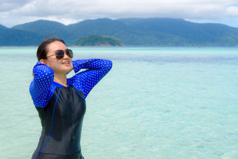 快乐亚洲青少年女孩泳衣和太阳镜放松的海附近的海滩下的蓝色的天空在旅行假期夏天利普岛塔鲁陶国家公园泰国亚洲青少年女孩放松的海在旅行利普泰国