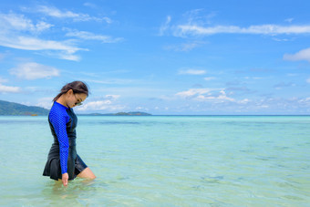 亚洲女人蓝色的<strong>泳装</strong>和太阳镜走的海和<strong>海滩</strong>看的清晰的水夏天天空旅行KOH利普岛塔鲁陶国家公园泰国亚洲女人走的海旅行KOH利普岛