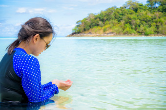 亚洲女人蓝色的泳装和太阳镜看的<strong>清晰</strong>的水他们的手的海夏天在的旅行KOH利普岛塔鲁陶国家公园satun泰国亚洲女人看的<strong>清晰</strong>的水他们的手的海
