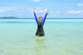 快乐亚洲青少年女孩泳衣玩溅水的海与有趣的下的蓝色的天空之旅假期夏天假期利普岛塔鲁陶国家公园satun泰国快乐亚洲青少年女孩玩溅水的海