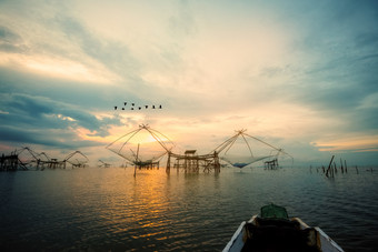美丽的自然景观金光的早....天空日出与群鸟是飞行本地的钓鱼工具和Prow农村生活方式pakpra运河跟踪先生为博他仑泰国农村生活方式pakpra运河在日出泰国