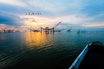 美丽的自然景观金光的早....天空日出与群鸟是飞行本地的钓鱼工具和Prow农村生活方式pakpra运河跟踪先生为博他仑泰国农村生活方式pakpra运河在日出泰国