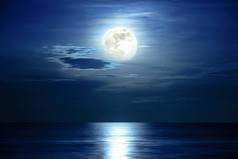 超级完整的月亮和云的蓝色的天空以上的海洋地平线午夜月光反映的水表面和波美丽的自然景观视图晚上场景的海为背景视图晚上场景的海