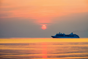 旅行巡航船的海洋大奢侈品乘客船航行的明亮的海红色的太阳的色彩斑斓的天空黄色的橙色美丽的自然景观日落日出背景旅行邮轮船的海洋日落