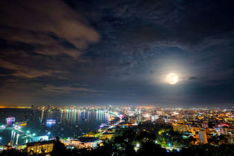 高视图的观点完整的月亮以上城市景观与色彩斑斓的光的海海滩芭堤雅湾美丽的景观芭堤雅城市晚上场景具有<strong>里</strong>程碑意义的<strong>春武里</strong>旅行亚洲泰国完整的月亮以上芭堤雅城市晚上泰国