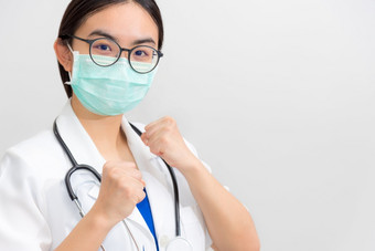 美丽的亚洲年轻的女人医生白色统一的和面具保护冠状病毒医生提高的拳头支持病人的战斗对疾病疫情科维德灰色的复制空间背景医生提高的拳头鼓励病人