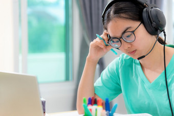 亚洲女人学生十几岁的女孩与眼镜耳机坐着看严重的阅读书担心使用移动PC电脑<strong>表</strong>格<strong>学习</strong>在线研究教育从类大学首页亚洲女人严重的阅读书<strong>学习</strong>在线