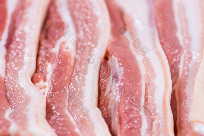 特写镜头前视图块新鲜的生肉猪肉肚子与白色脂肪和红色的粉红色的肉特写镜头块生猪肉肚子