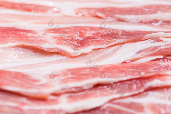 关闭前视图包培根块生肉新鲜的红色的猪肉与白色脂肪片是切片成薄条堆放前每一个其他特写镜头包新鲜的培根猪肉片