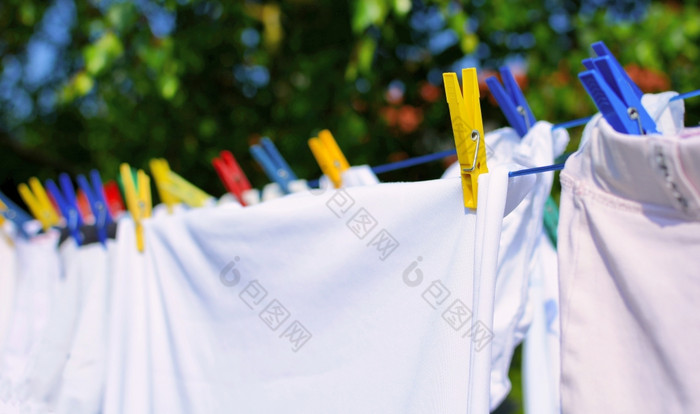 新鲜的白色洗衣挂的晾衣绳与色彩斑斓的挂钩