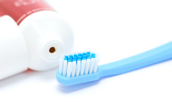 蓝色的牙刷和牙粘贴管白色背景特写镜头的每天牙科卫生工具