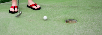 玩迷你高尔夫球低角特写镜头视图迷你高尔夫球球和高尔夫球俱乐部附近洞