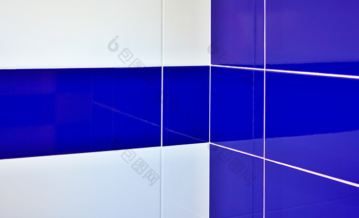 蓝色的和白色光泽瓷砖与白色关节浴室角落里