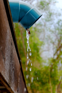 水倒从屋顶雨男孩落水管