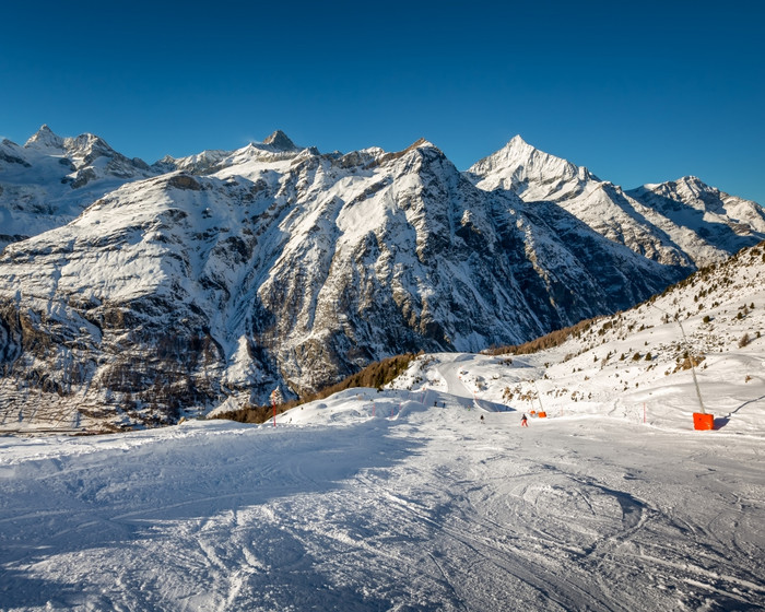 阳光明媚的滑雪坡和山山峰策马特瑞士