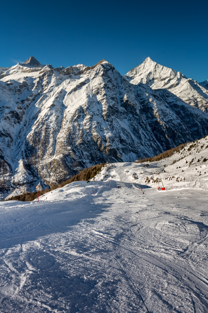 阳光明媚的滑雪坡和山山峰策马特瑞士