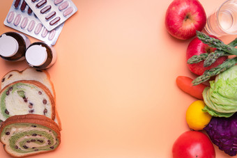 健康的食物水果和蔬菜对垃圾食物和supplemen健康的食物水果和蔬菜对垃圾食物和补充医学橙色背景