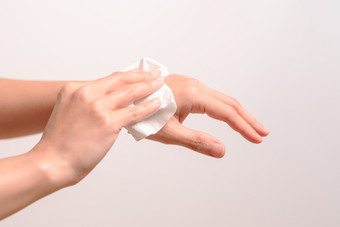 女人清洁她的手与白色软组织纸孤立的女人清洁她的手与白色软组织纸孤立的白色背景