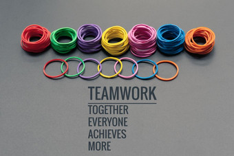 团队合作概念集团色彩斑斓的橡胶乐队黑色的背景与词团队合作在一起每一个人达到和更多的